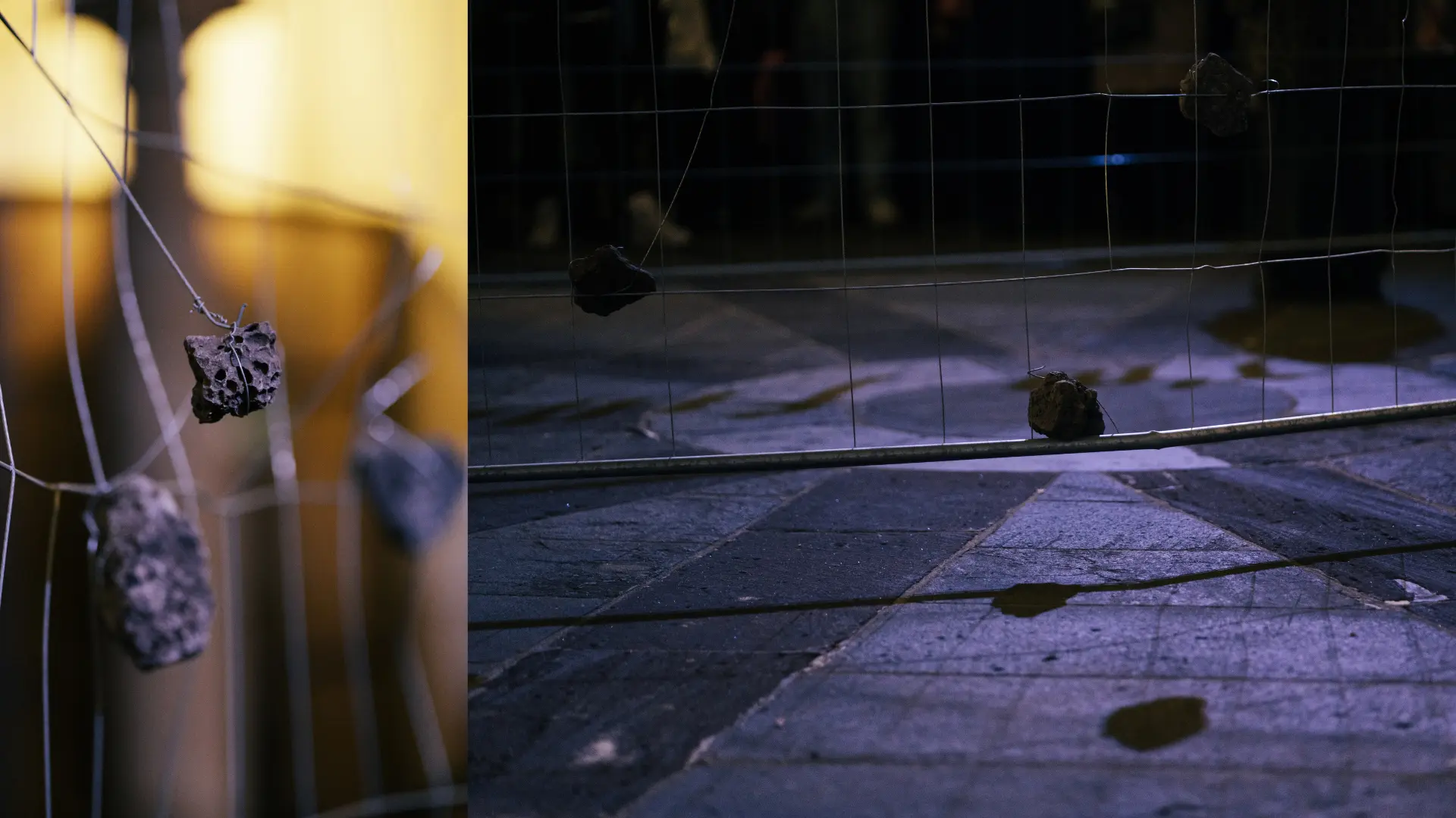 Dark exhibition installation featuring a metal gate structure and scattered sculptural elements on the floor.