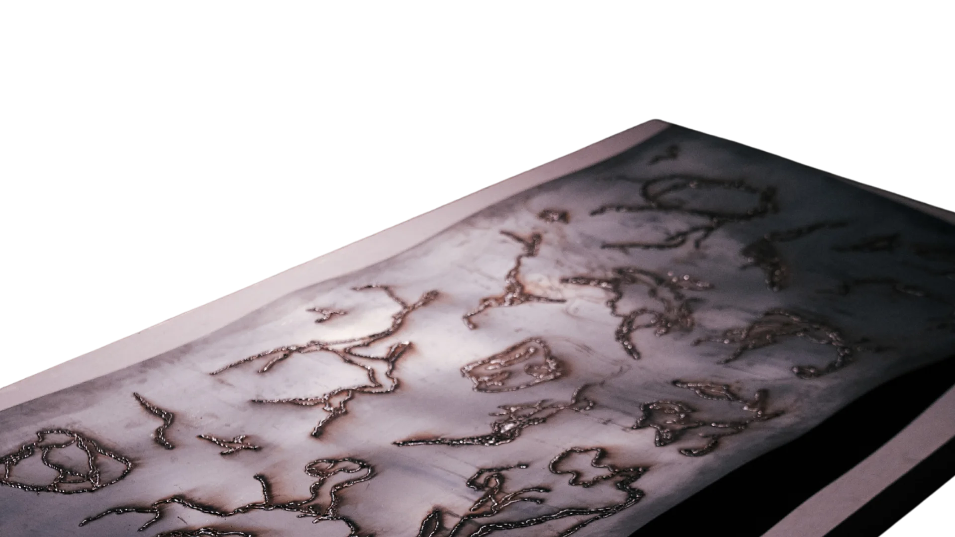 Angled photograph of a rectangular steel sculpture covered with irregular welded organic marks.