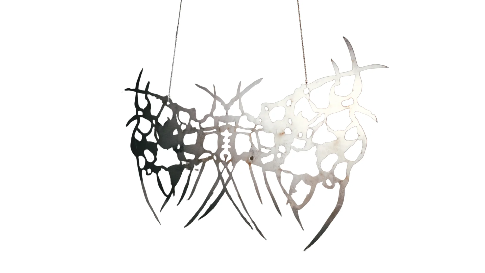 Abstract metal sculpture with branching, perforated organic forms suspended against a white background.