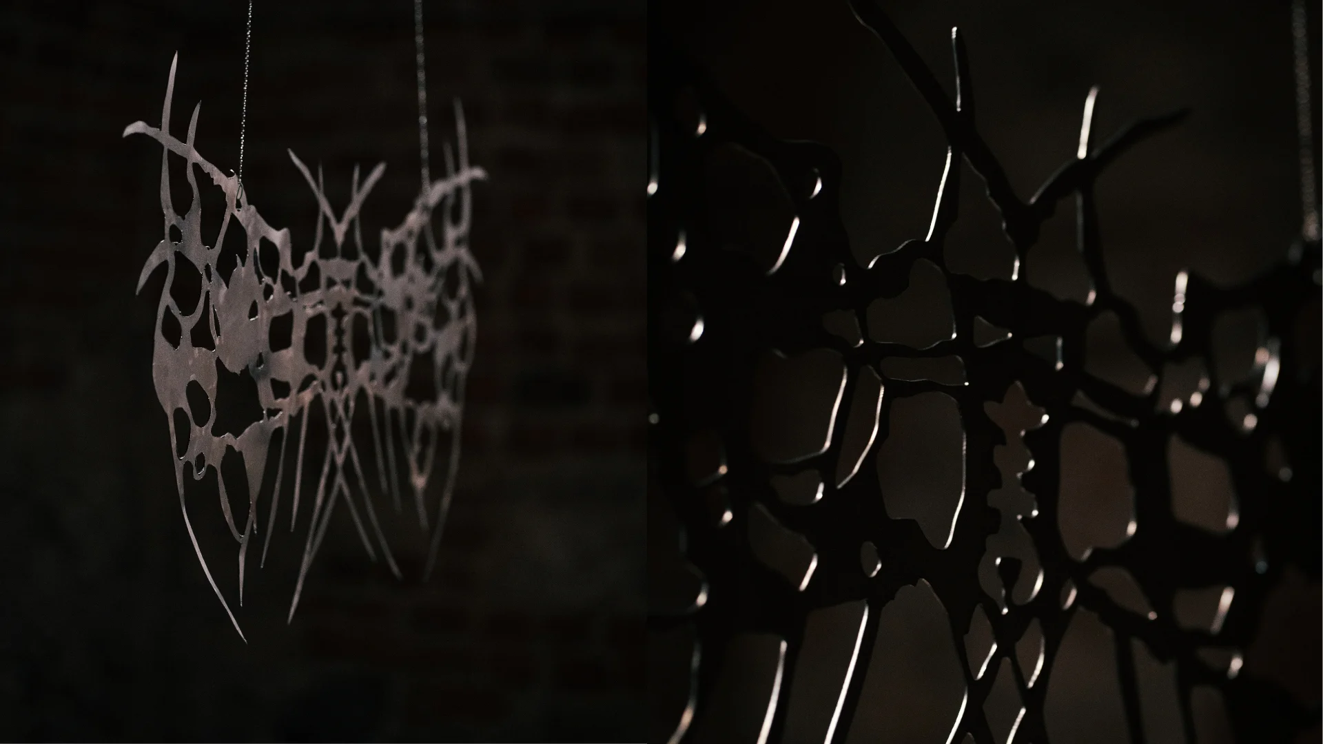 Close-up of an abstract branching metal sculpture in a dark brick gallery interior.